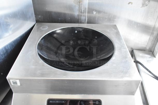 Induction stove inside a food trailer, branded Adventys, with stainless steel finish, showing minimal wear and clean surface.