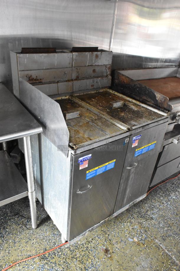 Fully equipped food trailer kitchen featuring Pitco fryers. Stainless steel with visible wear. Ideal for startup.