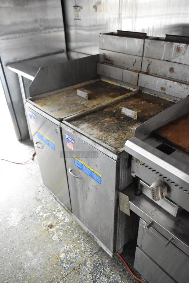 Stainless steel food trailer interior with Pitco fryers, worn condition, suitable for opening day operations.