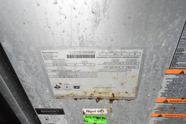 Pitco Frialator label on appliance, model 35C+S, 90,000 BTU. NSF certified. Serial number G21GD049690. Rusty metal surface.