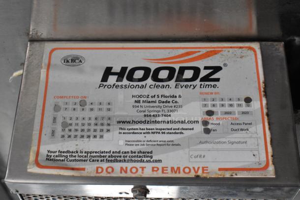 Hoodz inspection sticker on a food trailer, indicating professional cleaning and compliance with NFPA 96 standards.