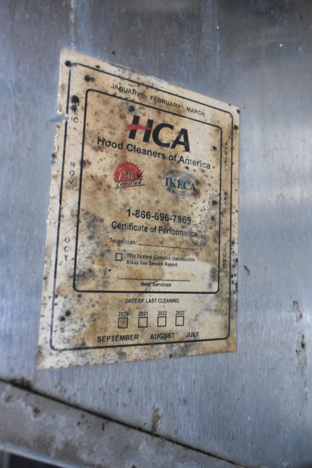 Worn HCA hood cleaning certificate on a food trailer, with service dates from 2020 to 2023 unchecked.
