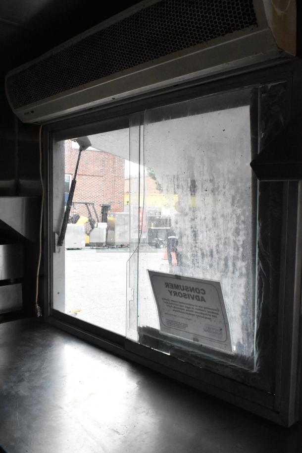 Fully outfitted food trailer interior with window, air vent, and consumer advisory notice visible.