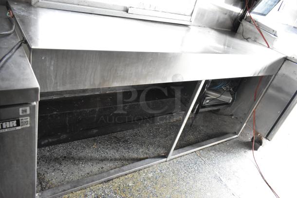 Fully outfitted food trailer interior with stainless steel countertop, storage space, and visible wiring. Ready for operation.