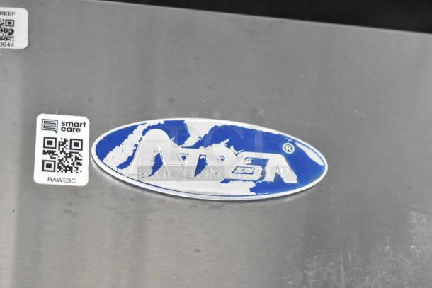 Atosa logo on stainless steel appliance in food trailer. Nearby are Smart Care QR code stickers, code "RAWE3C."