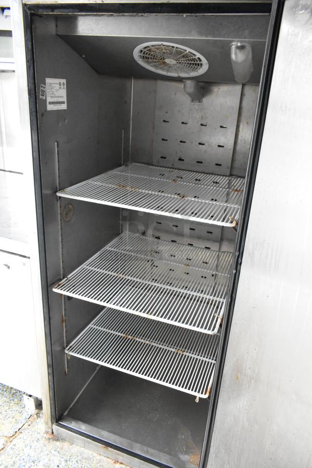Stainless steel food trailer refrigerator interior, three wire shelves, ventilation fan on top, suitable for commercial use.