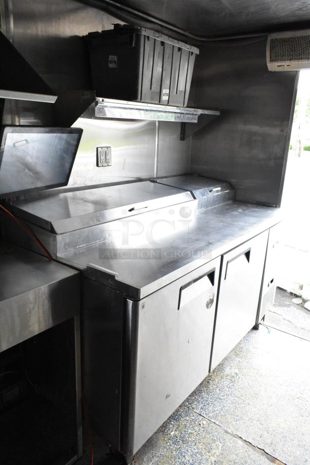 Stainless steel prep area in a fully equipped food trailer with under-counter refrigeration and storage bins. Clean and ready to use.