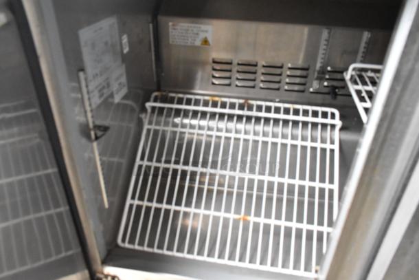 Interior view of a food trailer showing metal shelving and a ventilation panel, highlighting storage space and equipment layout.
