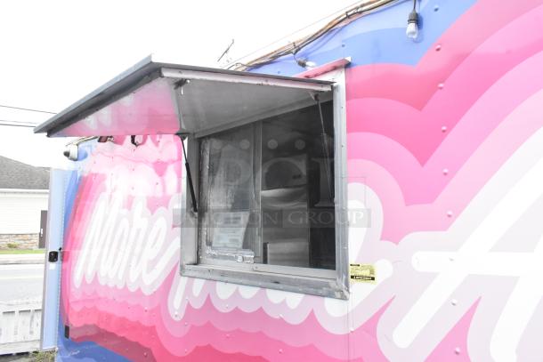 Colorful "More Than A Dream" food trailer with service window open, ready for business. Consumer advisory sign visible inside.