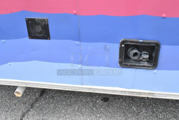 Colorful food trailer exterior with vents and utility connections, indicating well-equipped functionality. Good condition.