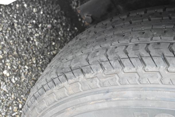 Close-up of a tire tread on a food trailer. Tread shows moderate wear, suitable for continued use.