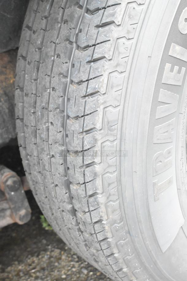 Close-up of a Travelstar tire on a food trailer, showing intact tread pattern and sidewall details.