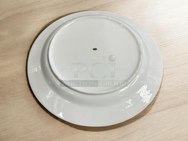 White 16" dining plate, like new condition, made in China, featuring smooth finish and minimalistic design.