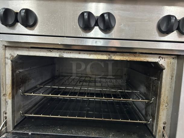 Wolf Commercial WX36-6B 36" gas range, stainless steel, 6 burners, 28 KBTU each, fully tested. Inside view with racks.
