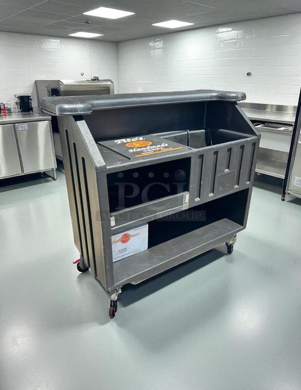 Cambro BAR540110 Cambar® Black 54" portable bar in excellent condition, includes 5-bottle speed rail, on wheels for easy mobility.