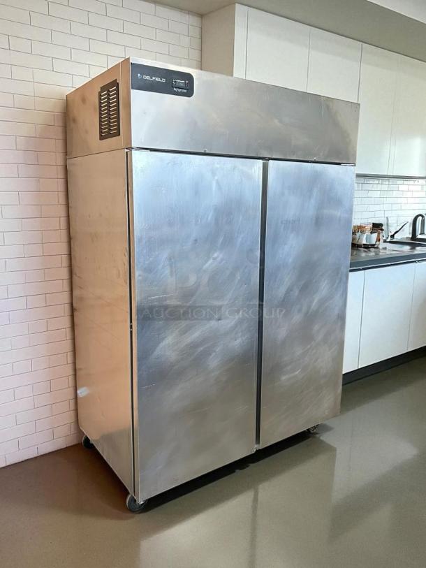 Delfield GBR2P-S refrigerator, 55 1/5", two solid doors, tested and working, excellent condition, visible branding and controls.