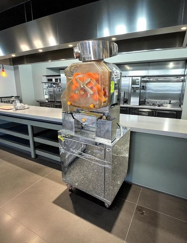 Citrocasa 8000 SB-ATS citrus juicer with base carriage, stainless steel finish, tested and working, visible in a kitchen setting.