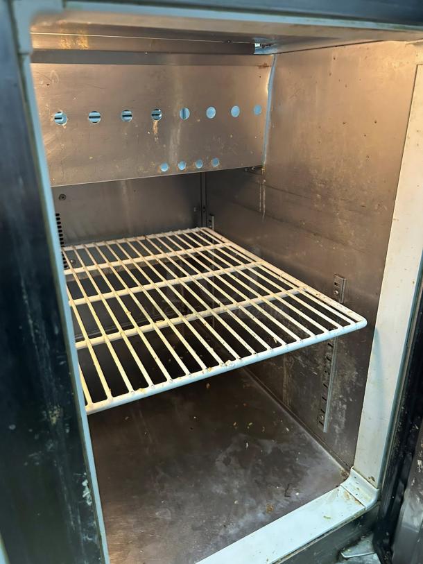 Everest EPR2-24 stainless steel sandwich prep table interior, showing shelving and clean condition.