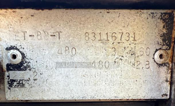 Metal identification plate with markings including "ET-88-T," "83116731," and voltage details. Appears worn.