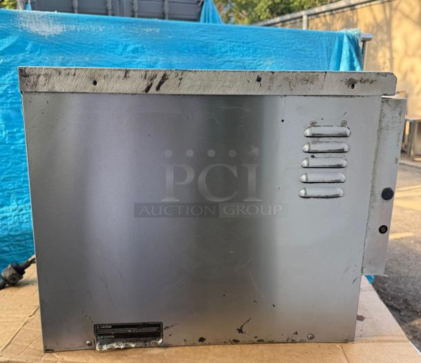 TurboChef NGC countertop rapid cook oven, stainless steel, used condition, side view with vent and caution label visible.