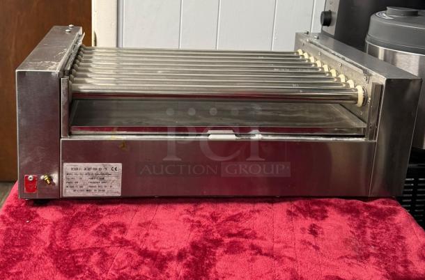 Hot Dog Roller Grill XCJ-9CZ-US with manual controls, slanted top, 120v. Stainless steel, good condition, visible label with specs.