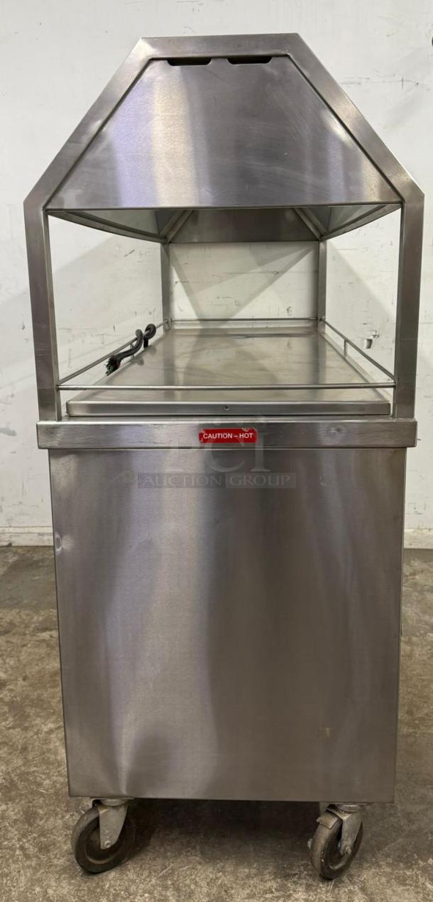 Stainless steel food warmer cart with glass display, mobile on wheels, "Caution - Hot" label, used condition.