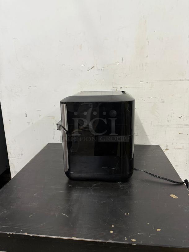 Instant Pot Vortex Plus 10, 7-in-1 air fryer toaster oven combo in black/stainless steel, 1500W, shown on a table.