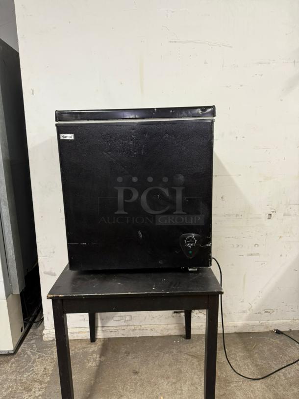 WANAI Deep Chest Freezer 3.0 Cu.Ft, model BC/BD-63, black, visible wear, Wanai branding label present, on a table.
