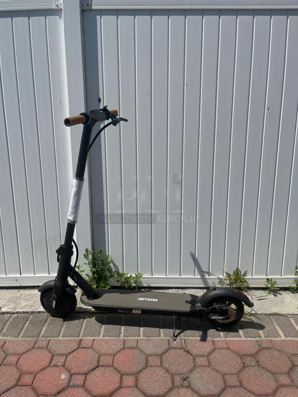 Jetson electric scooter with Bluetooth, foldable, hand-operated brakes, and headlights. Black frame, good condition.