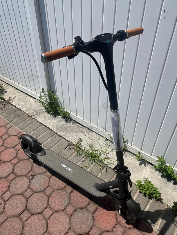 Jetson electric scooter, foldable with Bluetooth, hand-operated brakes, and headlights. Features brown grips and labeled deck.