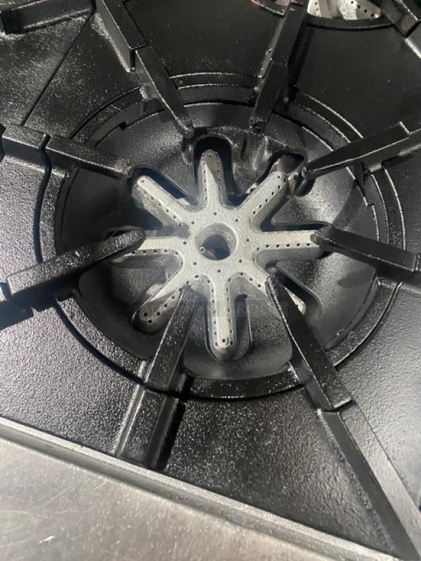 Garland H283 stove burner close-up, black cast iron grates, clean condition, part of 6 burner commercial range.