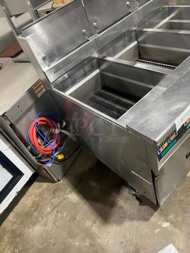 Pitco SSH60 stainless steel triple bay deep fryer system; 115v, natural gas, on casters, with backsplash and basket hanger.