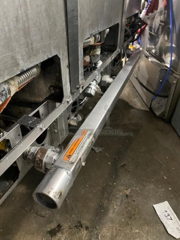 Pitco SSH60 commercial stainless steel triple bay deep fat fryer system, natural gas powered, on casters, with backsplash.
