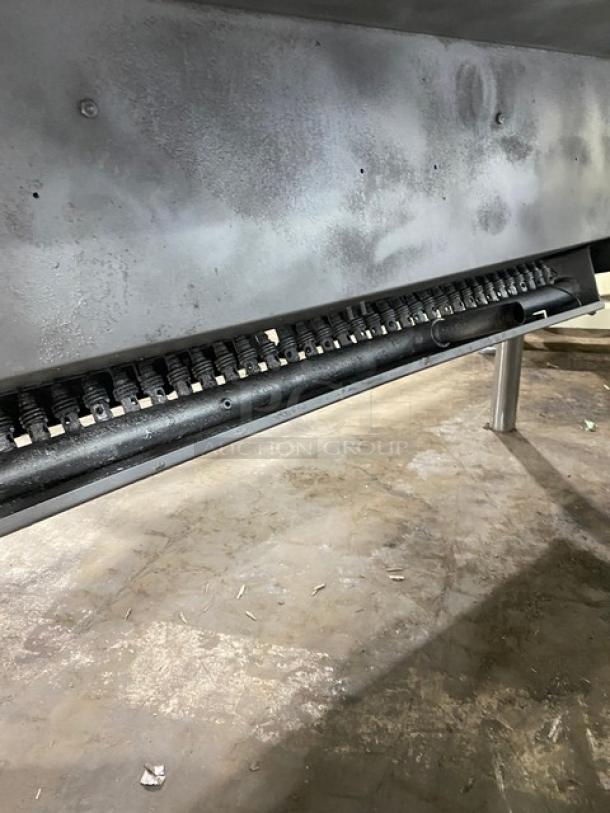 Commercial stainless steel natural gas tilt skillet on legs; shown in good condition, with visible gas mechanisms underneath.
