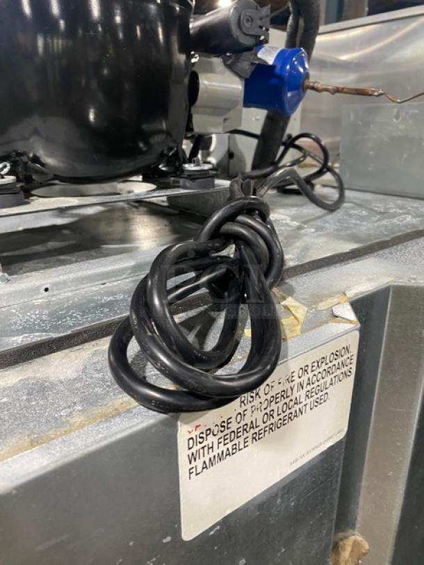 Continental 2RN refrigerator compressor detail, showing caution label and cord, highlighting industrial features.