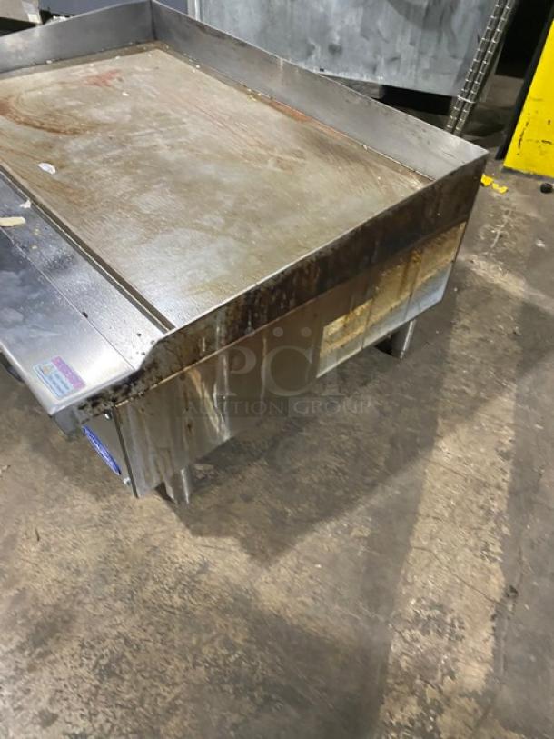 Cook Rite Atosa commercial stainless steel gas flat griddle with back and side splash on legs, showing surface wear.