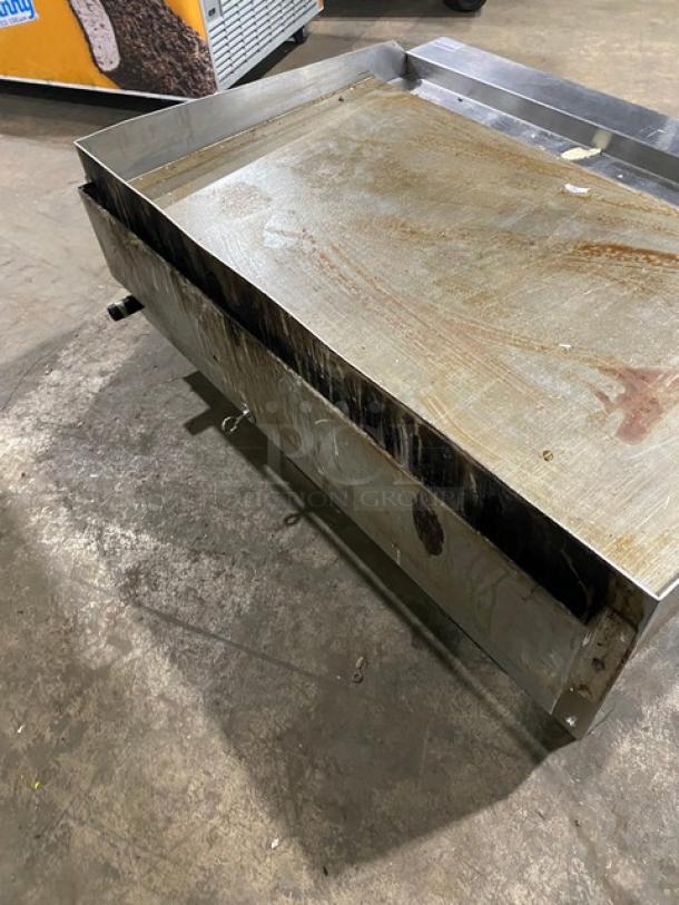 Cook Rite stainless steel natural gas countertop flat griddle, with back and side splash, on legs, shows signs of use.