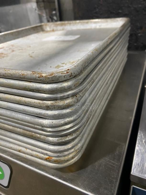 Stack of Don Commercial Aluminum Baking Pans, Model 1060717, showing signs of use with some surface wear.