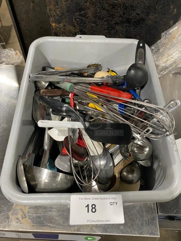 Lot of assorted commercial kitchen utensils in a bin, including whisks, ladles, tongs, and spoons. Mixed condition.