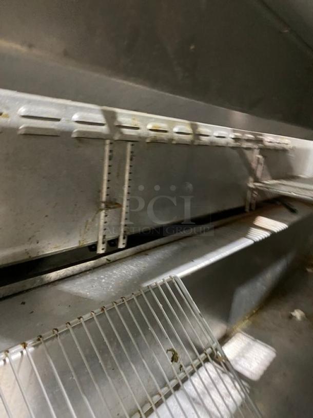 Continental 3-door stainless steel refrigerated prep table, model SW72-18, with polly-coated wire rack and casters.