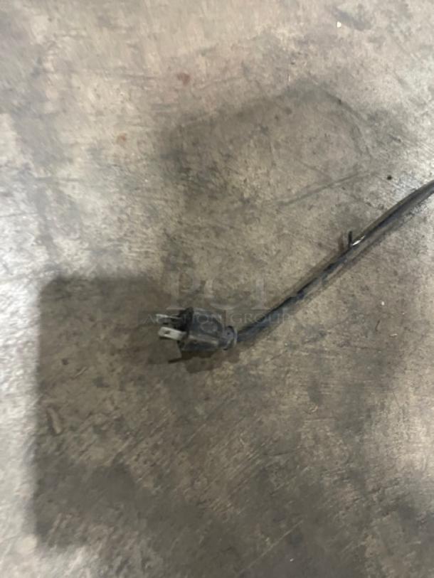 Power cord of GE Appliances Commercial Chest Freezer, Model FCM7SUFWW, shown on concrete floor.