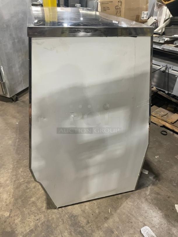 Custom Cool slanted glass refrigerated deli display with stainless steel finish. Features double sliding glass doors and storage.
