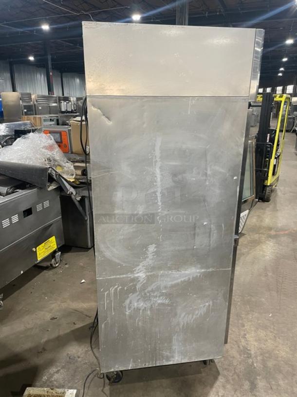 Continental commercial stainless steel single door reach-in refrigerator, model 1RN. Features built-in pan slides and casters. 115V, 1 phase. Serial: 15967901. Visible wear on surface.