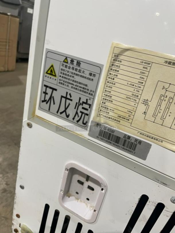 Commercial reach-in refrigerator, model LG-800BF, white, on casters, visible labels with technical specifications.