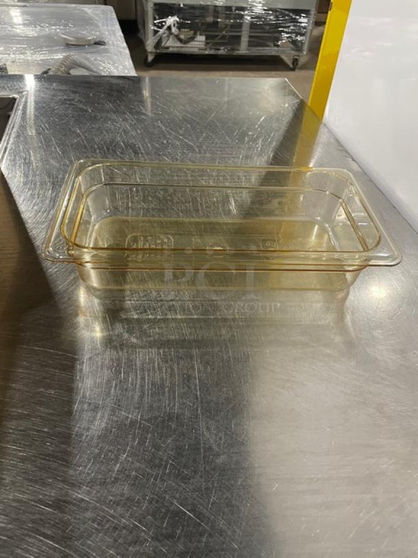 Brand new Cambro commercial amber high-temp 1/3-size 2" food pan, model 32HP150, on a metal surface.