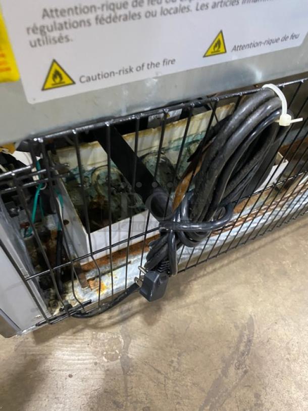 Arctic Air AR49EZ refrigerator back view, showing wiring and caution labels. Features stainless steel, 115V power, on casters.
