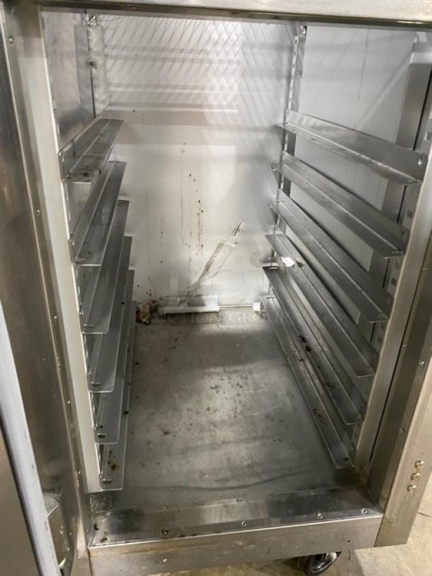 Traulsen AHT132DUT-HHS stainless steel single section reach-in refrigerator, wired racks, half door, on casters.
