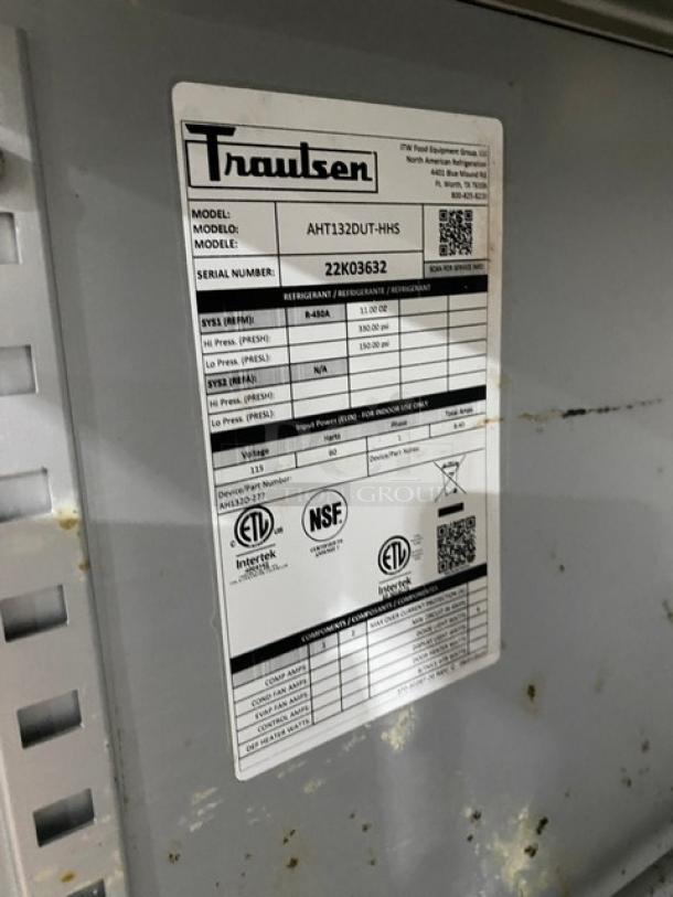 Traulsen stainless steel single-section reach-in refrigerator, model AHT132DUTHHS, with wired racks and caster wheels.