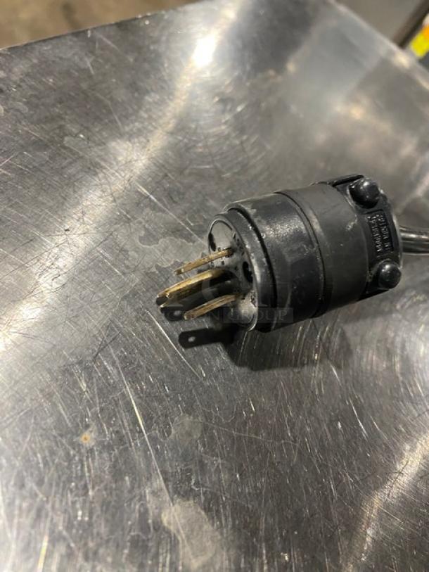 Electrical plug of Alto-Shaam 500S heated holding cabinet, showing prongs and black casing.