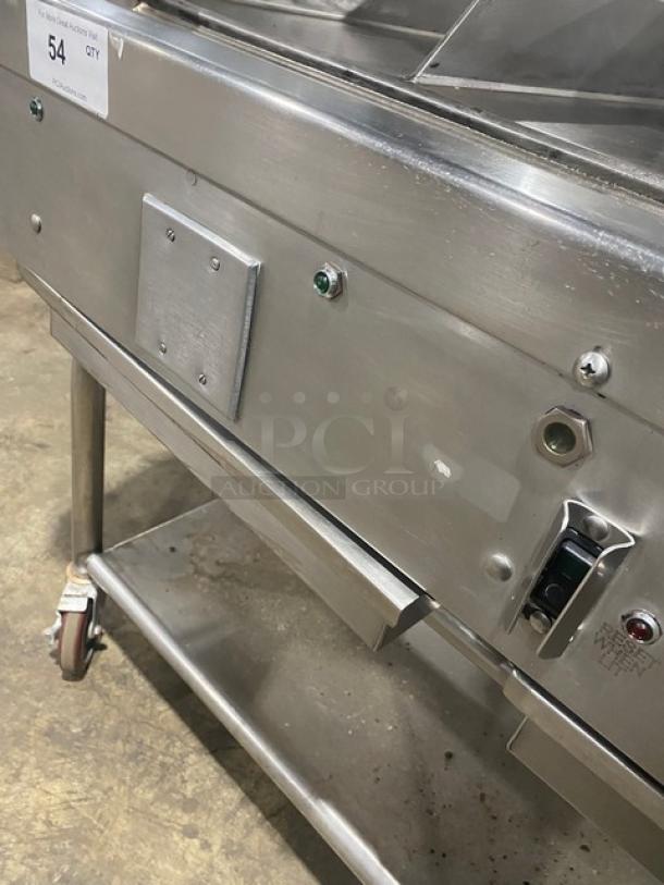 WoodStone stainless steel countertop plancha griddle with back and side splash, shown on an undershelf cart with casters.